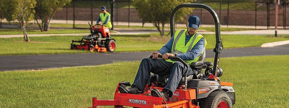 Two lawn mowers mowing the grass